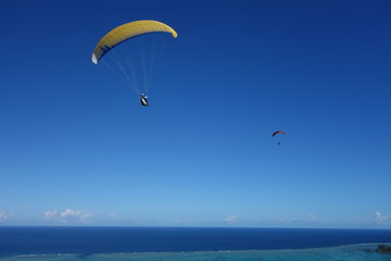 Fototapeta na wymiar Paragliding über dem Meer im Pazifik am Strand von Ishigaki Japan