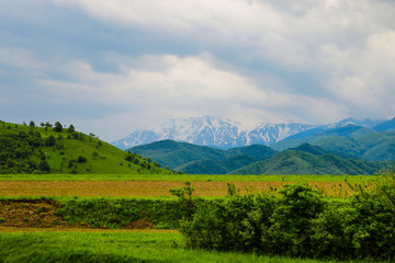 Mountains and dark sky on a rainy morning. Out of focus, nature background.
