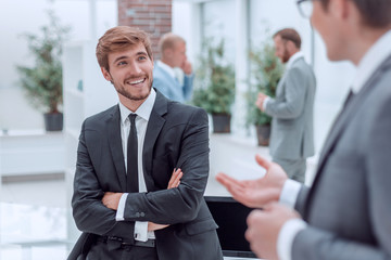 employees discuss their ideas standing in the office lobby