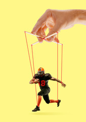Man like a puppet in somebodies hands on yellow background. Concept of unfair manipulation,...