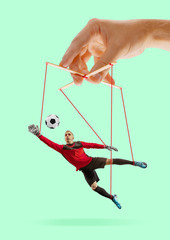 Man like a puppet in somebodies hands on green background. Concept of unfair manipulation,...