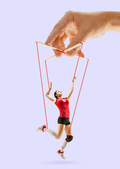 Woman like a puppet in somebodies hands on purple background. Concept of unfair manipulation,...