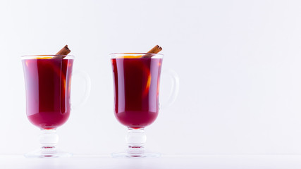 Glass of hot mulled wine with spices on white background. Christmas mulled wine with orange, star anise and cinnamon. Two glasses of winter Christmas drink
