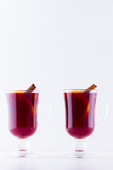 Glass of hot mulled wine with spices on white background. Christmas mulled wine with orange, star anise and cinnamon. Two glasses of winter Christmas drink