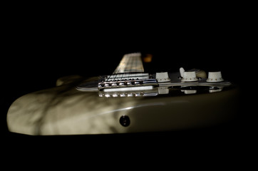 White electric guitar on black background.