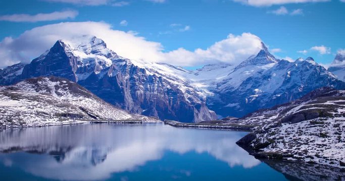 Bachalpsee lake in highlands of Switzerland near Grindelwald village during Autumn season. Snow capped mountain ridge during sunset.