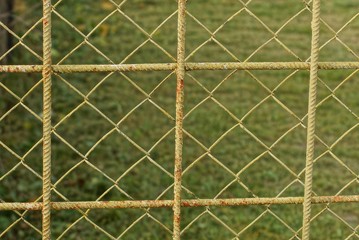 yellow metal texture of mesh and iron bars in the fence