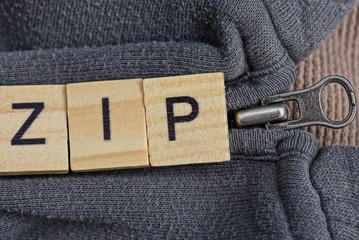 word made of  letters and metal zip on gray part of clothes
