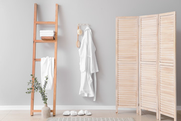 Clean bathrobe hanging on wall in room