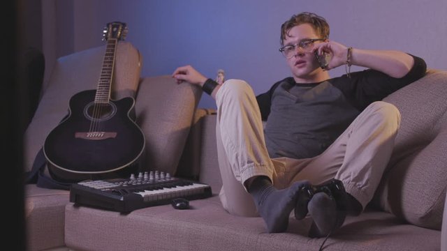 Multitasking Man Playing Video Game with Feet While Talking on the Phone