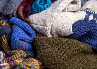 Heap of multi-colored knitted warm clothes are ready for cold autumn and winter.