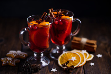 Mulled wine with aromatic spices and fruits on wooden rustic table, copy space. Traditional Christmas time hot drink