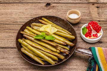 Baked green bean in pan with sesame seeds, mint and lemon. Healthy vegan (vegetarian) food concept