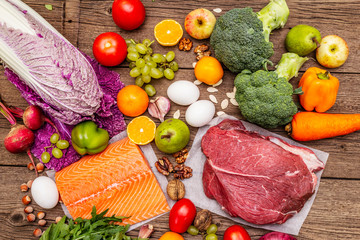 Trending paleo/pegan diet. Healthy balanced food concept. Set of fresh products, raw meat, salmon, vegetables and fruits