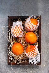 Granadilla tropical fruit in a wooden crate on a background with old stucco