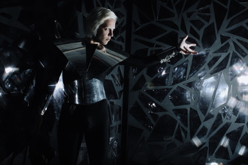 young blonde caucasian man standing in alien cosmos halloween costume and looking near the many mirrors and reflecting on black background