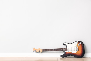 Modern bass guitar near white wall