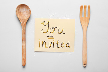 Invitation with kitchen utensils on white background