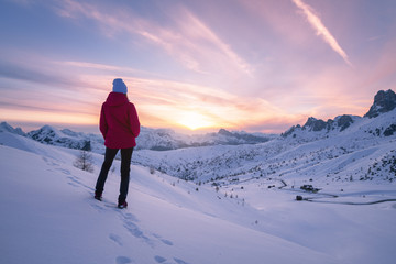 Young woman in snowy mountains at sunset in winter. Landscape with beautiful slim girl on the hill...