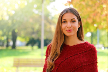 Pretty beautiful woman standing in front of the camera outdoor in autumn season. Copy space.