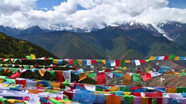 Tibetan buddhist prayer flags blowing in the wind with Meili snow mountain in backgroung in Yunnan, China