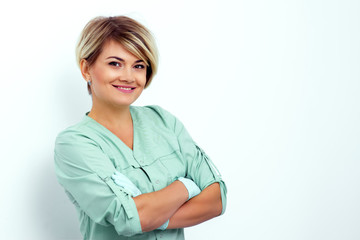 Portrait of adult smiling female beautician doctor with crossed arms on white background.