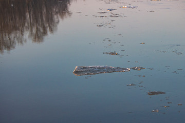 spring ice drift on the river in muddy water before high water and flood, front and background blurred with bokeh effect