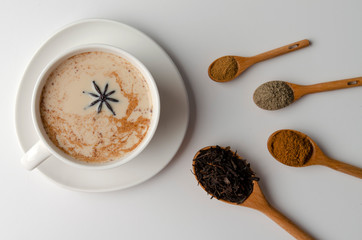 Traditional indian masala chai tea with spices - cinnamon, cardamom, anise, white background. Top...