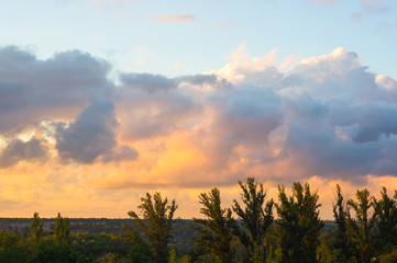 Landscape with dramatic light - beautiful golden sunset with saturated sky and clouds.