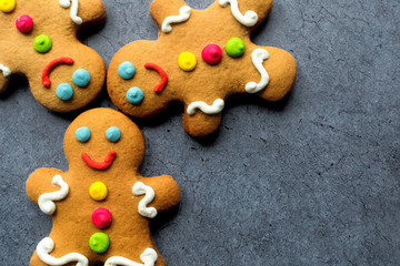 Delicious Christmas gingerbread men.Christmas baking ingredients and supplies on dark background.Postcard. Congratulation.Cooking. Christmas cookie man.Christmas minimalism.close up.copy space