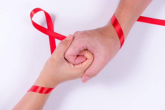 World AIDS Day. Man and woman holding hands with Red ribbon. Aids Awareness.