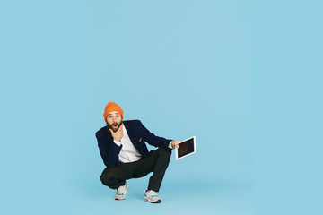Young caucasian businessman having fun dancing break dance on blue studio background. Management, flexible, freedom, professional occupation, alternative way of modern working. Loves his job