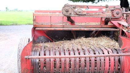 Closeup shot of red vintage tractor and  agricultural vehicle / making hay bales
