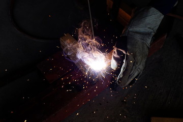 Welder workshop training a welding metal with protective mask and uniform in factory