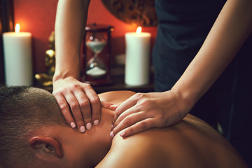 Obraz na płótnie Canvas Masseur doing neck massage on man in the spa salon.
