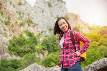 Happy asian traveller woman with backpack standing at stone hill  and smiles. Summer holiday and vacation trip , Survival travel, lifestyle concept.