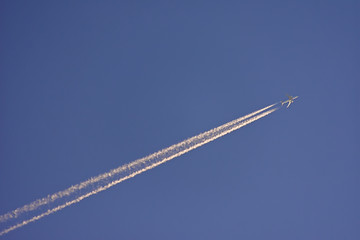 Avião voando a grande altitude deixa estela de vapor branca no céu Copy space