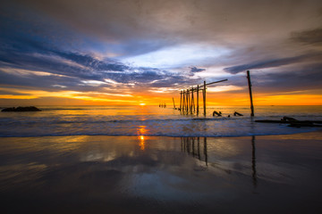 The blurry background of the colorful night sky on the large lake, the brightness of the light that hits the water surface and the wind blows cool, with the rotten wooden bridge over time, a viewpoint