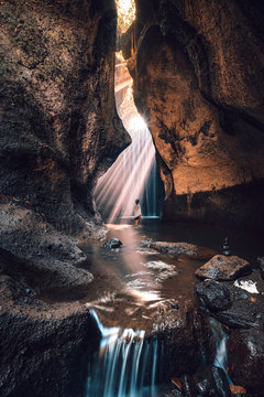 Traveling with tropical rainforest rock in Bali enjoying life at beautiful Lighting hidden tukad cepung waterfall.