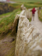Fototapeta na wymiar thin stone wall - cliffs of moher - blurry background