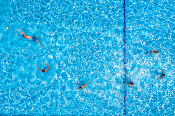 Swimming pool with playing people, overhead view
