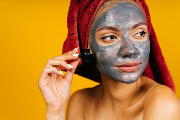 beautiful girl with a black cosmetic mask on her face. in isolation