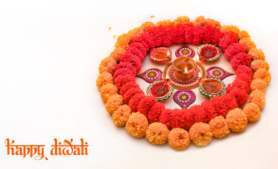 Diwali background content with rangoli pattern on white floor decorated with traditional clay diya lamps and flowers