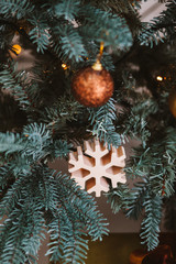 Obraz na płótnie Canvas Christmas decorations on the New Year tree. Wooden snowflake.