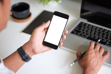 Cropped shot view of man hands holding smart phone with blank copy space screen for your text message or information content, female reading text message on cell telephone during in urban setting. 
