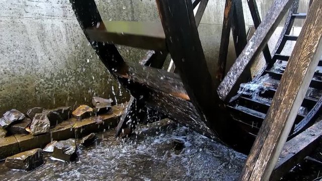Wooden Water Mill Wheel Spinning. Slowmotion Zoom Out of a Spinning Water Mill.