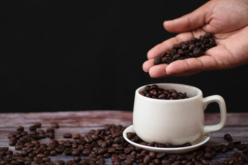 White coffee mugs on a wooden table with coffee beans on the floor.