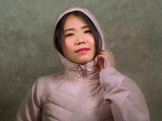 beauty and fashion style isolated portrait of young beautiful and cool Asian Japanese student woman in pink hood winter jacket smiling happy and cheerful isolated © TheVisualsYouNeed