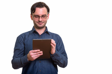 Studio shot of formal young man using digital tablet