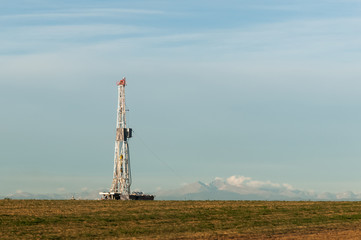 Olil rig in the morning with mountains in the background